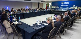 #Acessibilidade #ParaTodosVerem | Sala de conferências com participantes reunidos em torno de me...