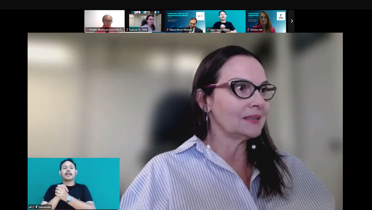 Print de uma tela de reunião na plataforma Zoom. Na parte superior há algumas janelas abertas co...