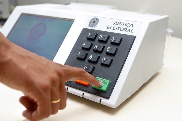 urna biométrica Mão masculina confirmando voto na urna eletrônica.