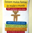 Foto de cartaz colorido com urso de braços abertos e sorriso com descrição da campanha para redu...